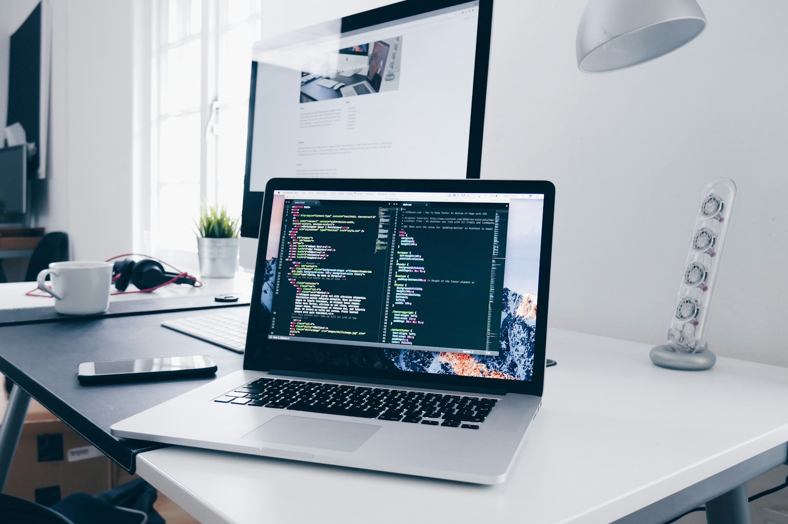A sleek modern desk with multiple monitors displaying lines of code, dark themed text editor, mechanical keyboard, futuristic lighting, high-tech workspace, no people